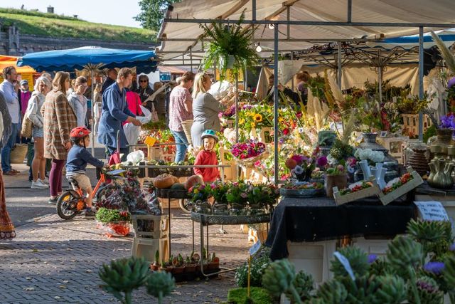 Zaterdagmarkt in Naarden-Vesting. Op de foto zijn volwassenen en kinderen te zien bij een bloemenkraam.