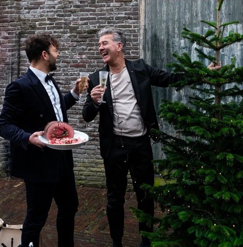 Twee mannen feestelijk op de foto met een product van Slagerij Taam