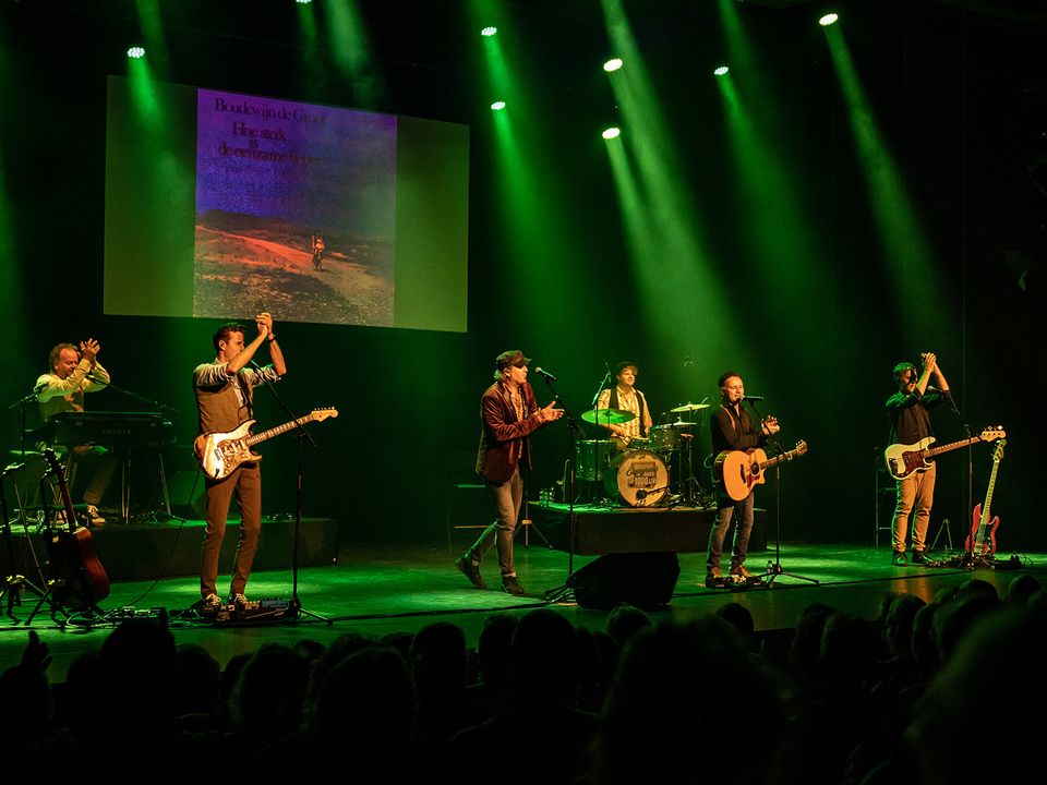 Een band die op het podium staat met groene spotlights