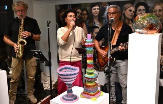 Drie personen maken muziek in een atelier.