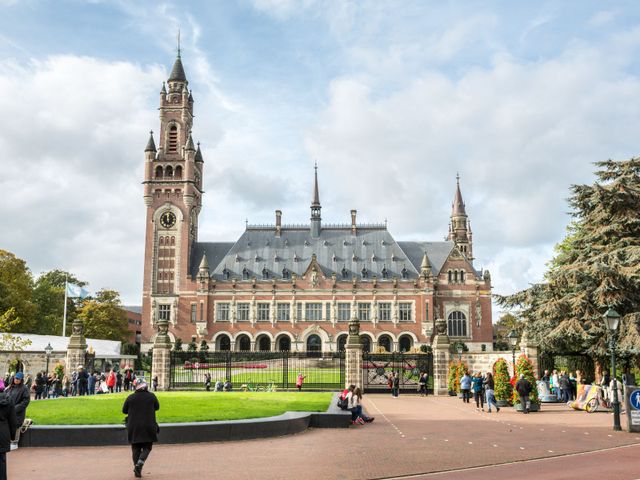 Toeristen op het voorplein van het Vredespaleis. Het Vredespaleis staat symbool voor Den Haag als stad van vrede en recht.