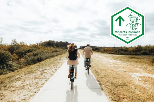 Een man en een vrouw fietsen door het uitgestrekt natuurgebied Bargerveen.