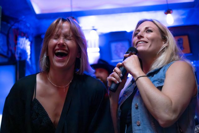 Twee jonge vrouwen zingen karaoke