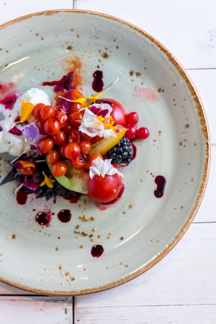 bordje prachtig opgemaakt met eetbare bloemen en verse bosvruchten