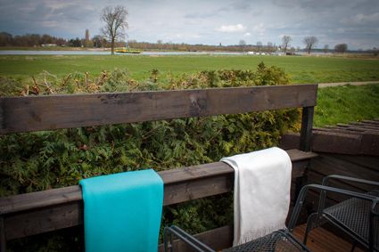 Privetuin met plateau met uitzicht op de Maas bij Bed & Breakfast De 2e Kamer
