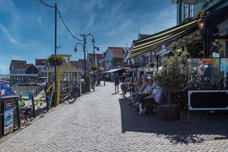 Mensen die op een terras zitten aan De Dijk in Volendam