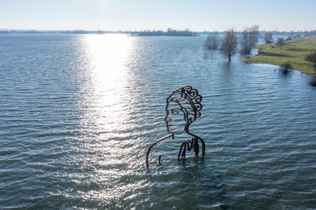 Het beeld De Baadster tot haar schouders onder water in de Byland
