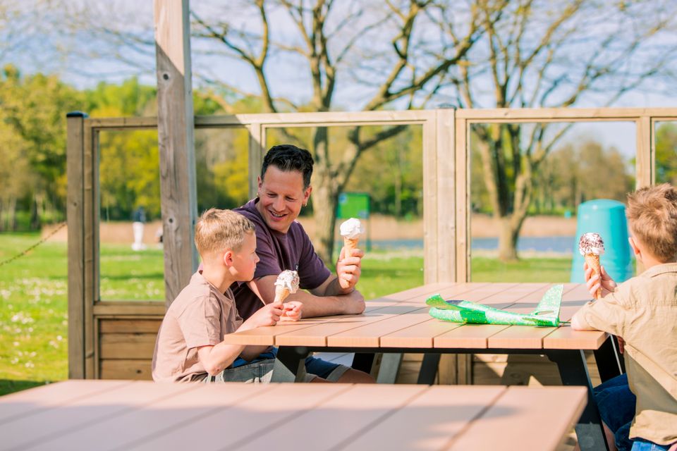 Gezin eet ijsje op het terras.