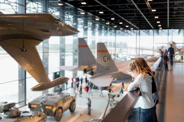 Kinderen kijken uit over vliegtuigen, auto's en tanks