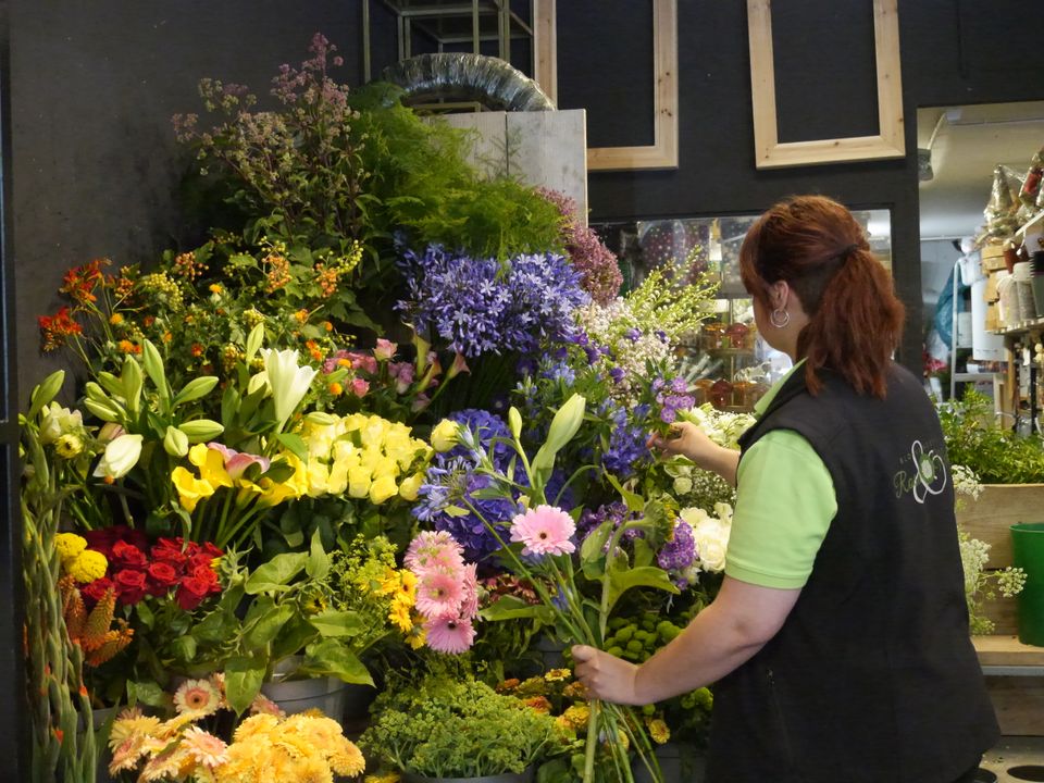Een vrouw die bloemen aan het schikken is bij Bloembinderij Roses & More in Volendam