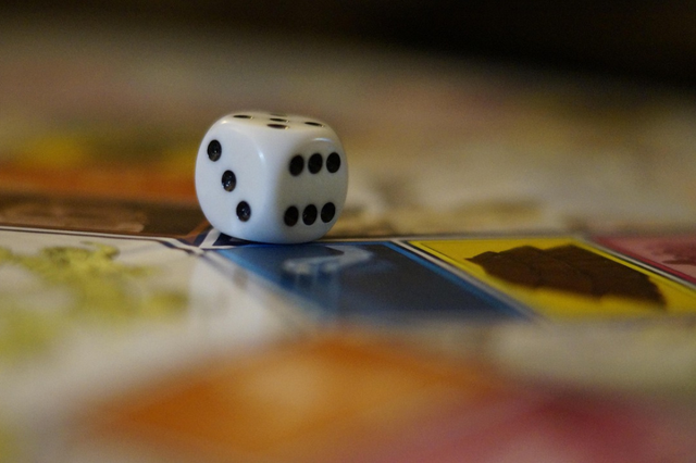 Ein Würfel auf einem Brettspiel.