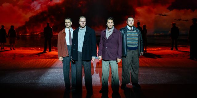 Four man standing on a stage