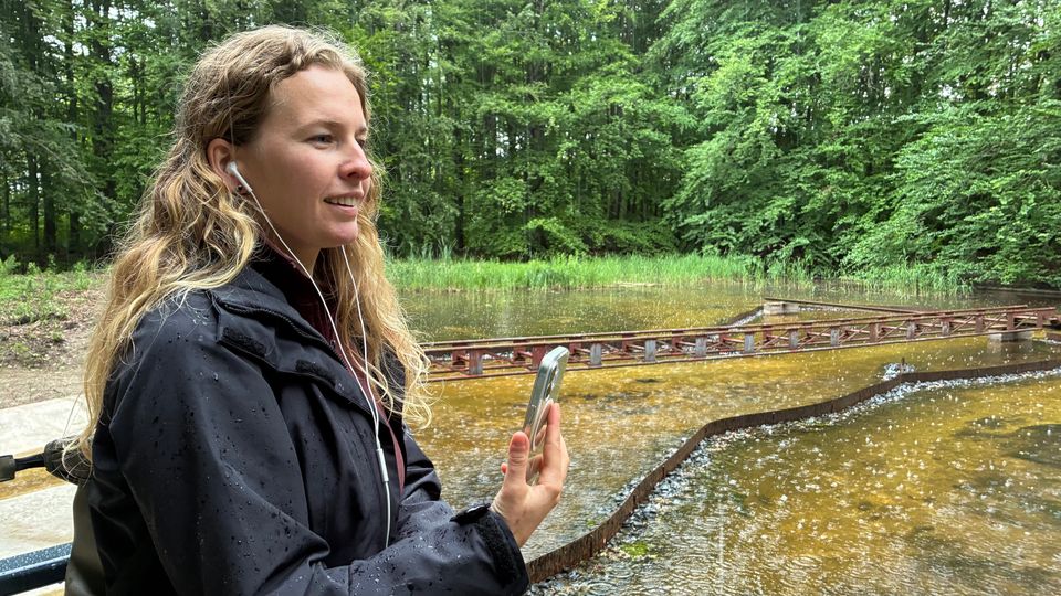 Een vrouw luistert naar de podwalk Natuurgeheimen