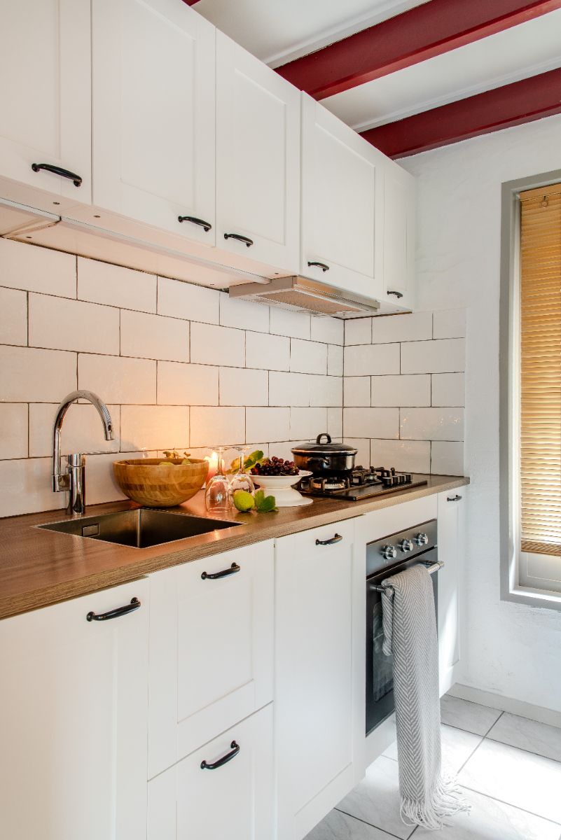 Fijn ingerichte keuken met gasstel, koelkast, oven en vaatwasser.