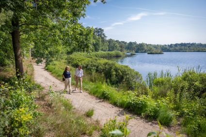 Twee vrouwen wandelen al kletsend over het met veel groen omgeven pad langs het Voorste Goorven