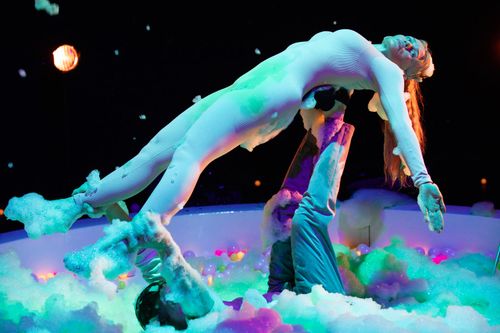 Een man die een vrouw in de lucht tilt met handen en voeten