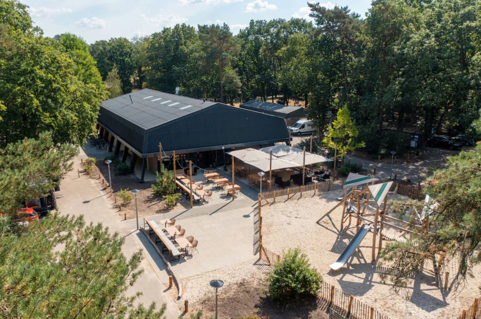 Roompot park De Peel Deurne - Hauptgebäude mit Terrasse und Spielplatz