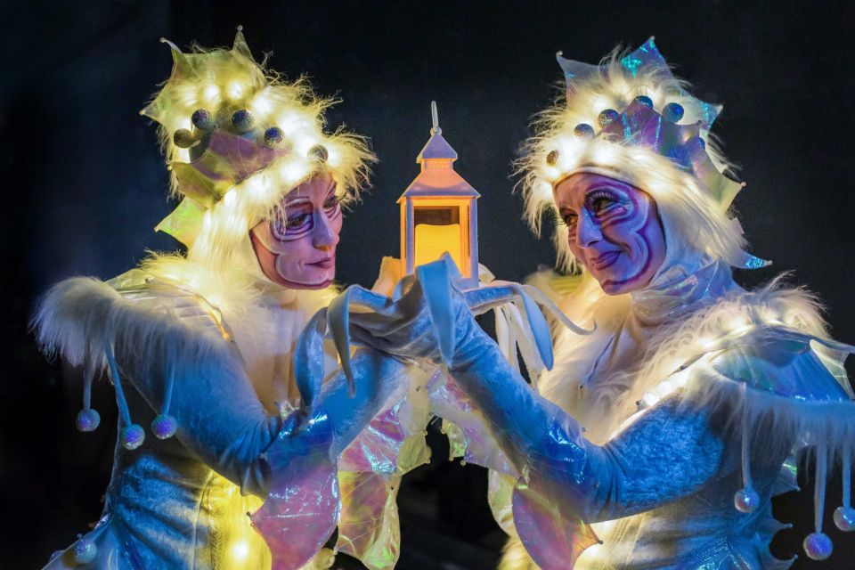Tijdens de lichtjeswandeling in Woerden delen verlichte figuren een warm moment in de avond. Het zachte licht van de lantaarn en de fonkelende kostuums zorgen voor een magische sfeer vol verwondering.