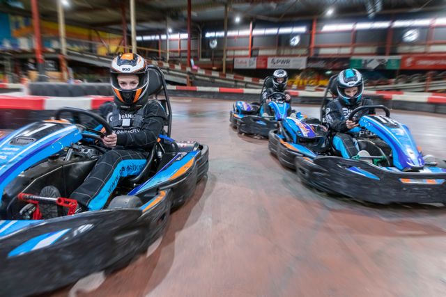 Drie mensen in karts bij Gamecity in Zoetermeer.