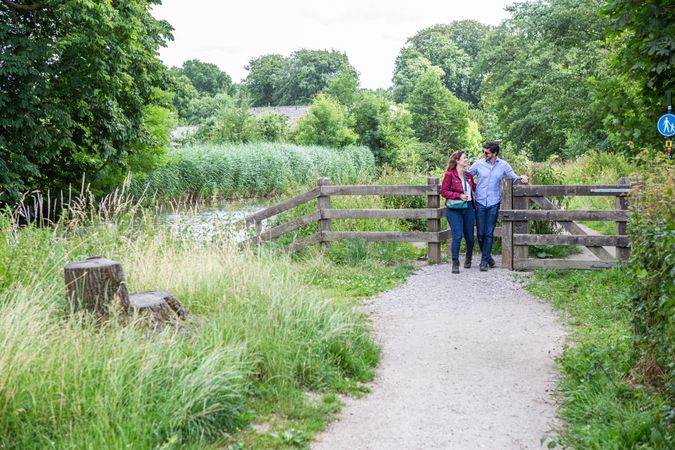 Twee wandelaars passeren een hekje langs de Kromme Rijn