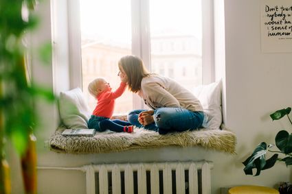 Mom and child are sitting in a windowsill