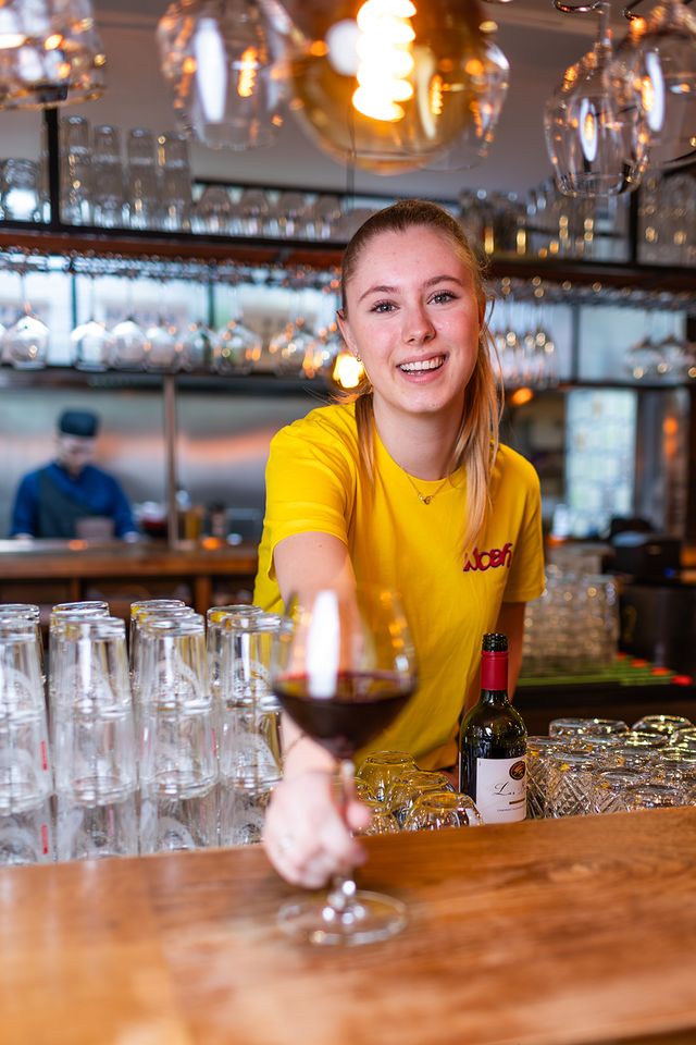 De bediening serveert een wijntje