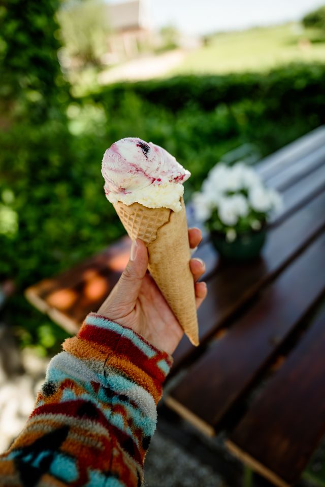 Een arm van een persoon met een schepijsje in de hand.