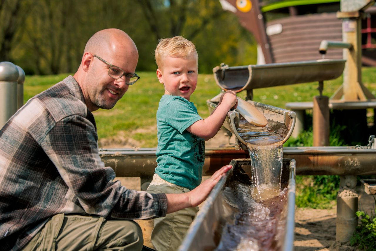 vader en kind spelen met water