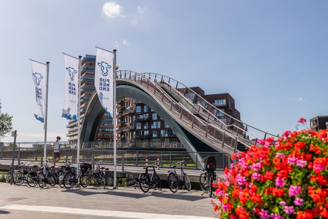 Een foto van de Melkwegbrug met bloemen in Purmerend