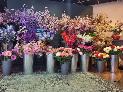 Bloemenwinkel Bloemenwinkel Stek in Woerden, Groene Hart, kleurrijke zijdenbloemen boeketten in emmers en vazen gepresenteerd in de winkel met diverse kunstbloemen en interieurdecoratie.