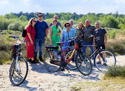 Groep fietsers poseert voor de heide van natuurgebied Kampina