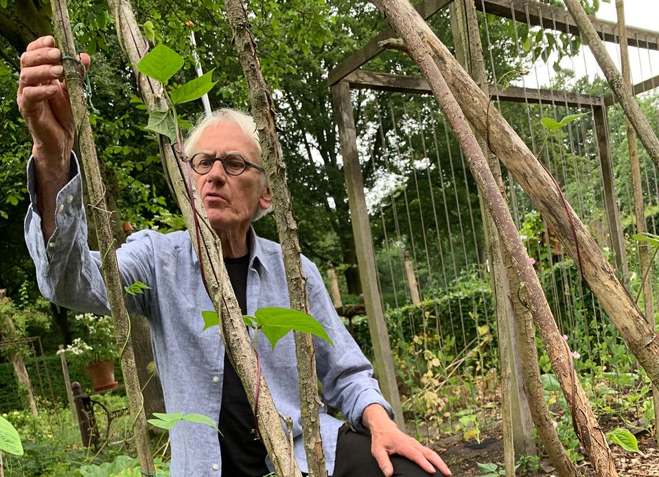 Harm Jan Luth die in de tuin aan planten zit