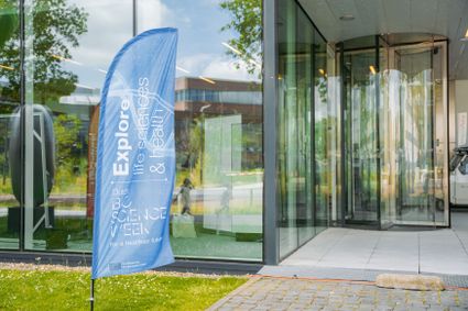 A blue Dutch Bio Science Week banner next to a door bearing the words ‘Explore Life Sciences and Health’.