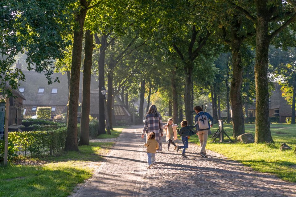 Een gezin met drie kleine kinderen loopt door monumentendorp Orvelte.