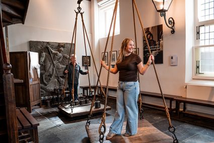 Museum De Heksenwaag in Oudewater, Groene Hart, met bezoekers bij de historische weegschaal en het interieur van het museum.