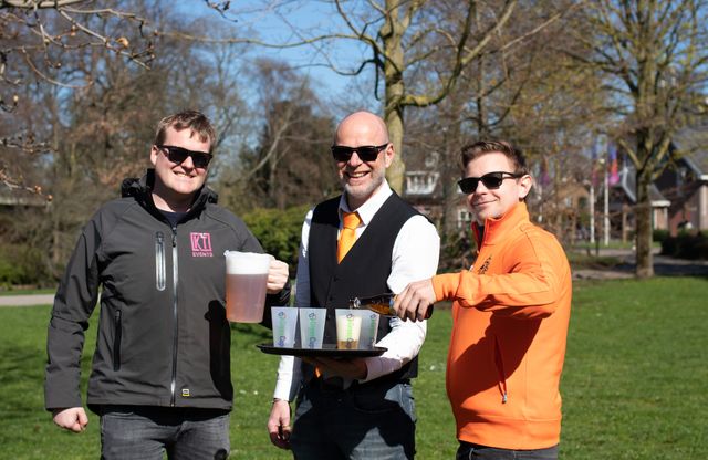 Drie mannen waarvan de linker een kan drinken vast heeft de middelste een dienblad met bekers en de rechter een glas aan het inschenken is.