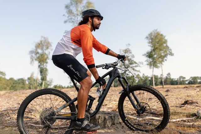 Man pauzeert tijdens mountainbike tocht door de Drentse natuur.