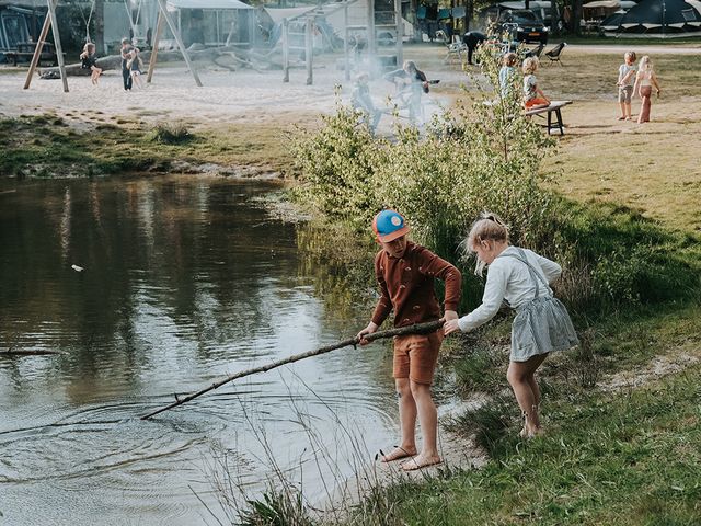 Twee kinderen spelen aan de waterkant bij Charme Camping Hartje Groen