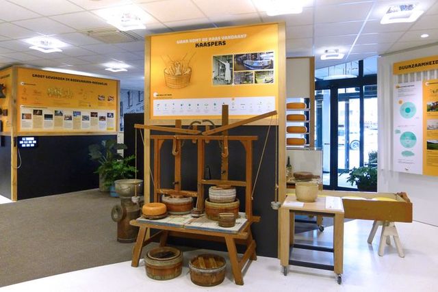 Tentoonstelling over de herkomst en bereiding van kaas in het Kaasmuseum in Bodegraven, met traditionele gereedschappen, kazen en informatiepanelen.