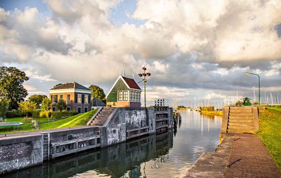 Een oude sluis die openstaat van een afstandje gezien.