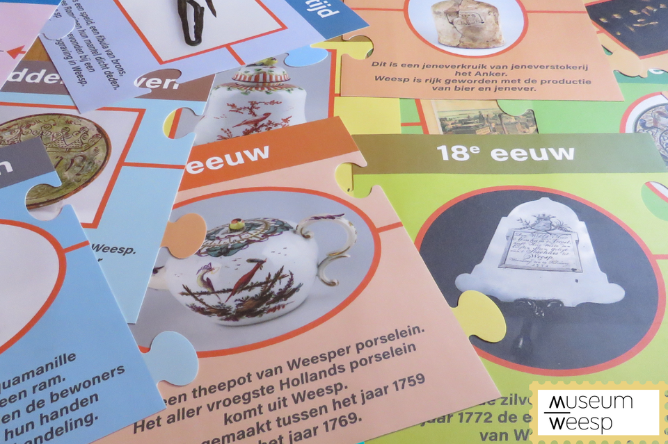 Grote puzzelstukken van de vloerpuzzel liggen door elkaar in Museum Weesp.