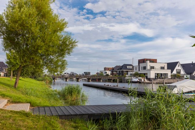 Nieuwbouw woningen bij het water met een steiger in Almere, Flevoland