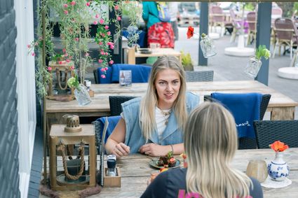Twee jongedames die met elkaar koffiedrinken bij Grenzeloos in Doldersum