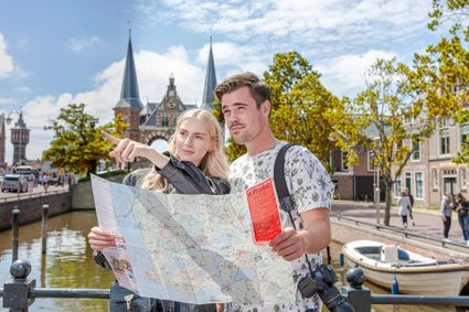 Jong stel voor de Waterpoort in Sneek met een plattegrond om de 7 schatjes van de 7 stadjes te ontdekken.