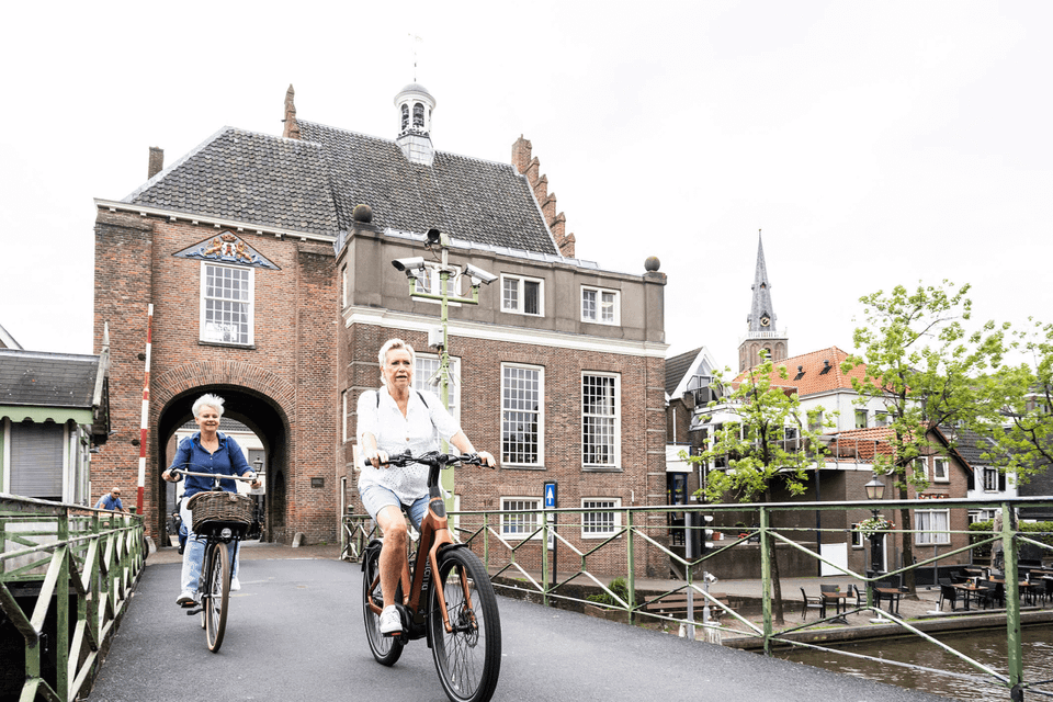 Dames fietsen over draaibrug in Montfoort