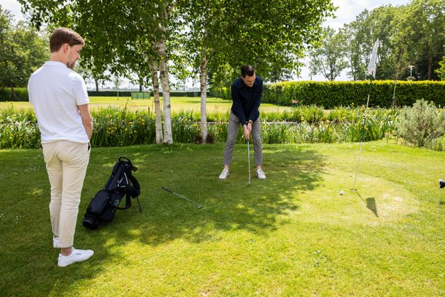 Twee deelnemers oefenen met putten tijdens een golfclinic op het groene terrein van Buitenplaats Kameryck.