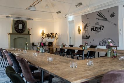 Vergaderruimte en restaurant Plein 7 in Woerden met lange tafels en sfeervolle inrichting.