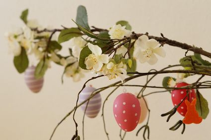 Paastak met witte bloesem en gekleurde paaseitjes