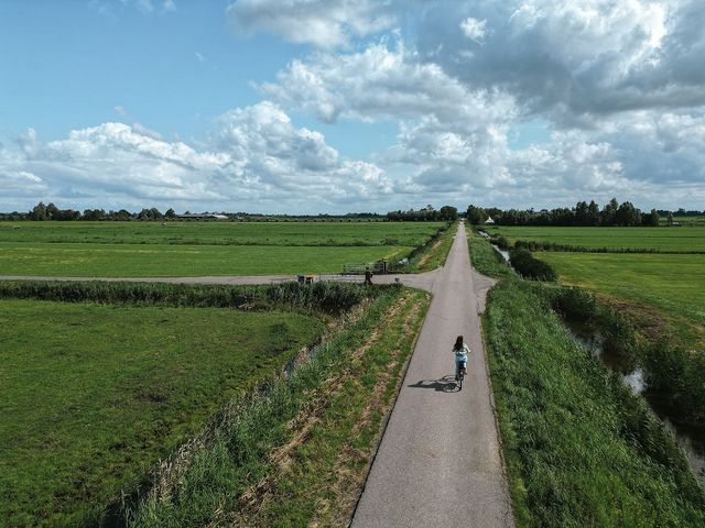Fietser door het boerenlandschap van Amsterdam Noord.