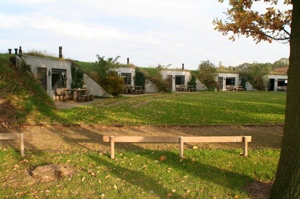 Verblijfsaccommodaties van De Boerenstee, deels ingebouwd in het groene landschap en voorzien van eigen terrassen. De foto laat een rustige, landelijke plek zien voor een verblijf in de natuur.